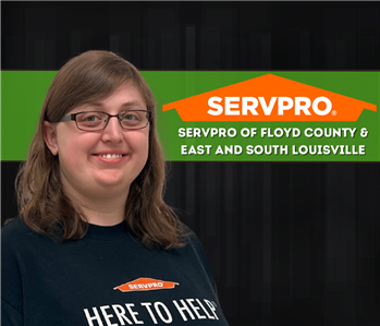 woman smiling at the camera on a black background with a SERVPRO logo